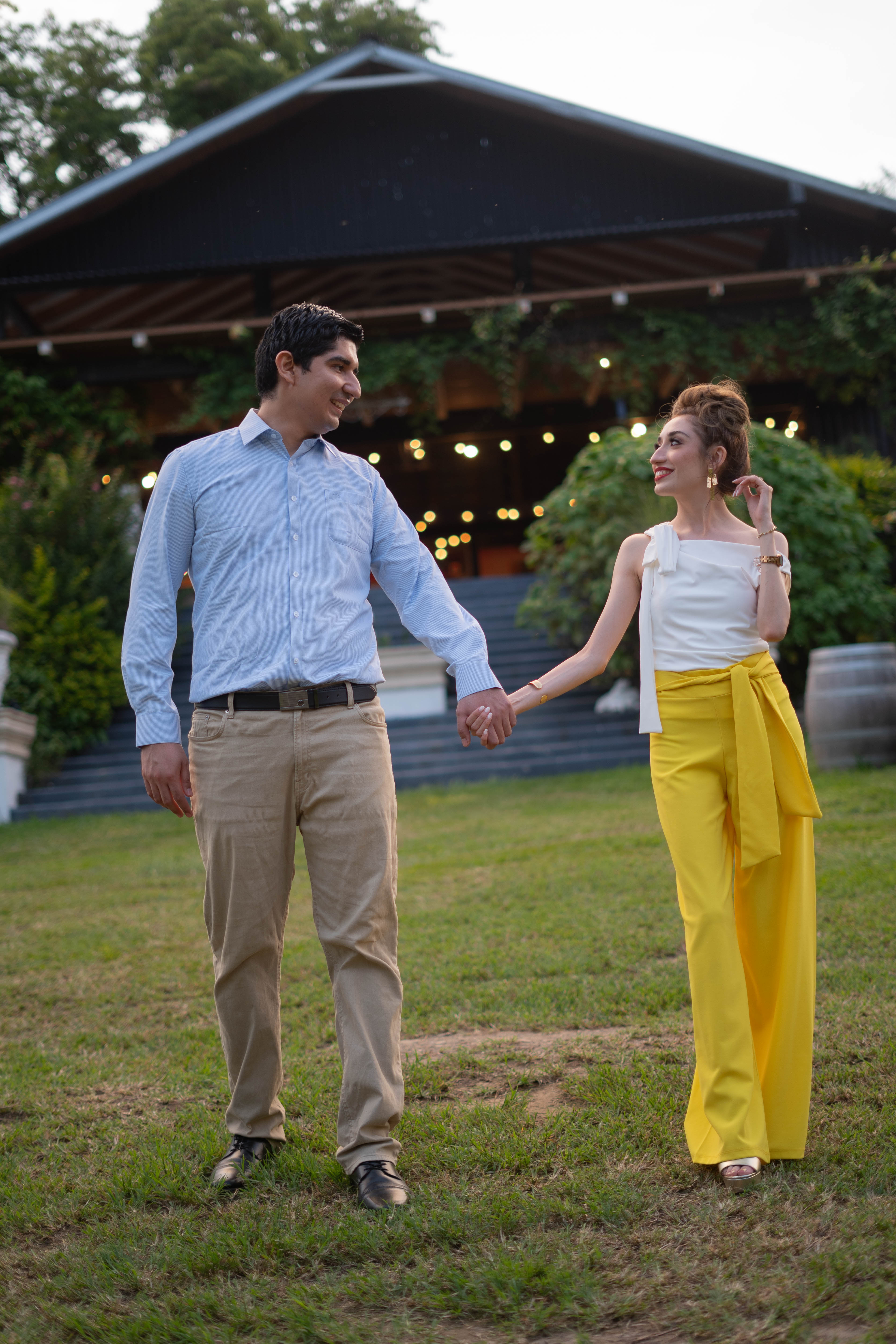 The couple walking through the hacienda courtyard at dusk